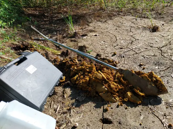 Fond d'un bassin d'infiltration colmaté. Argile à meulière orangé mise en évidence vers 0,5 m du fond des bassins lors du diagnostic Enysol